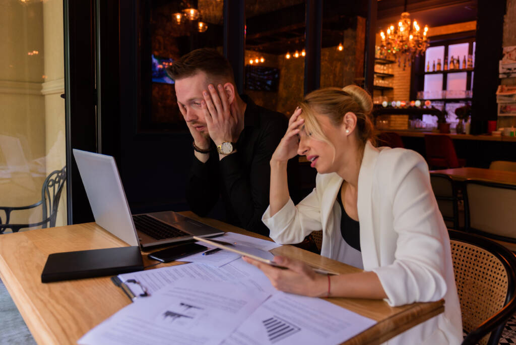 Shot of a man and woman going through paperwork together during a meeting in a cafe
